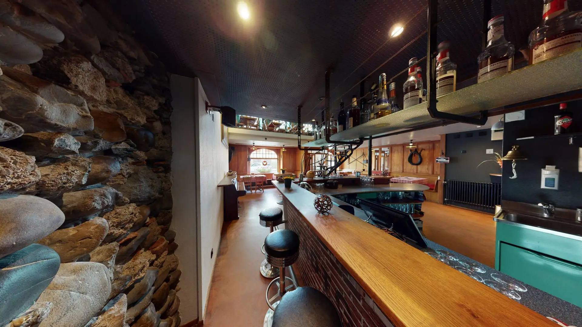 Bartresen mit Spirituosenregal und Natursteinwand im Stübli des Restaurant Stadtgarten Wangen