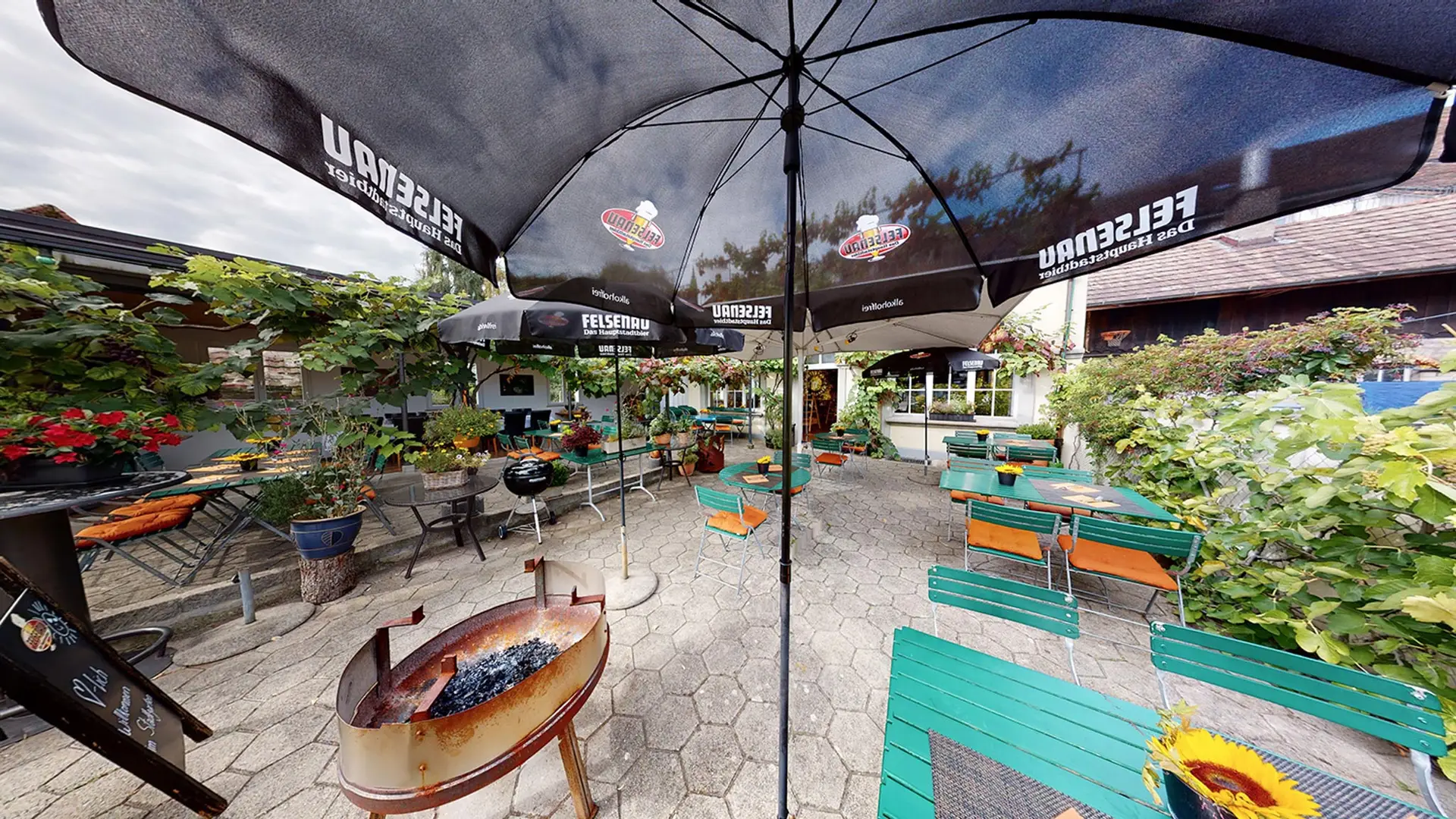 Aussenbereich der Gartenterrasse mit Sonnenschirmen und Feuerstelle im Restaurant Stadtgarten Wangen