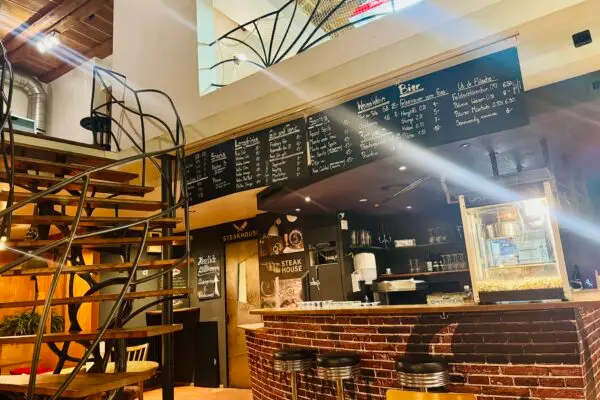 Stübli Bar im Restaurant Stadtgarten Wangen – Innenansicht mit Backsteinbar, schwarzer Wendeltreppe und Kreide-Getraenkekarte