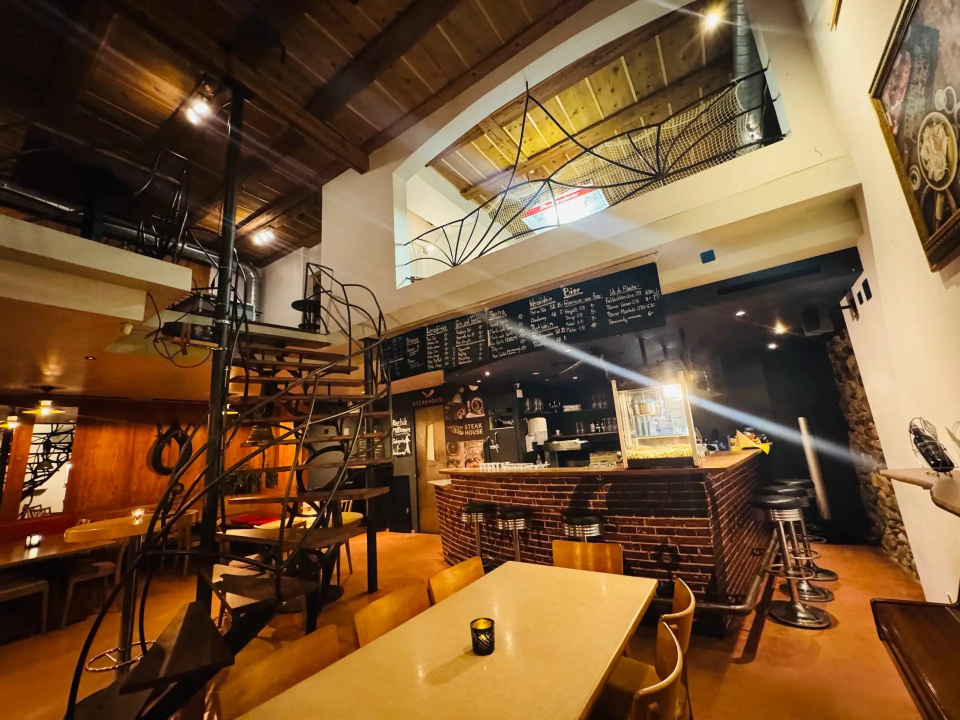 Vogelperspektive auf die Stübli Bar des Restaurant Stadtgarten Wangen mit Wendeltreppe und Kreidetafel