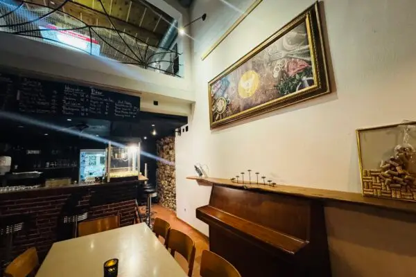 Eleganter Gastraum im Restaurant Stadtgarten Wangen mit Kunstgemälde an der Wand und Kreidetafel-Karte im Hintergrund