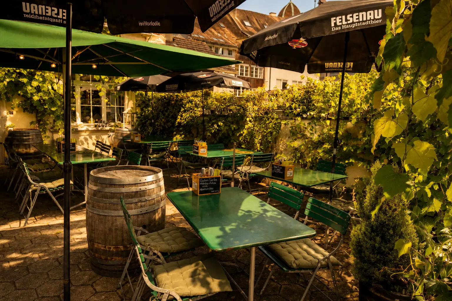 Gastgarten mit Sonnenschirmen und Weinfass im Restaurant Stadtgarten Wangen an der Aare