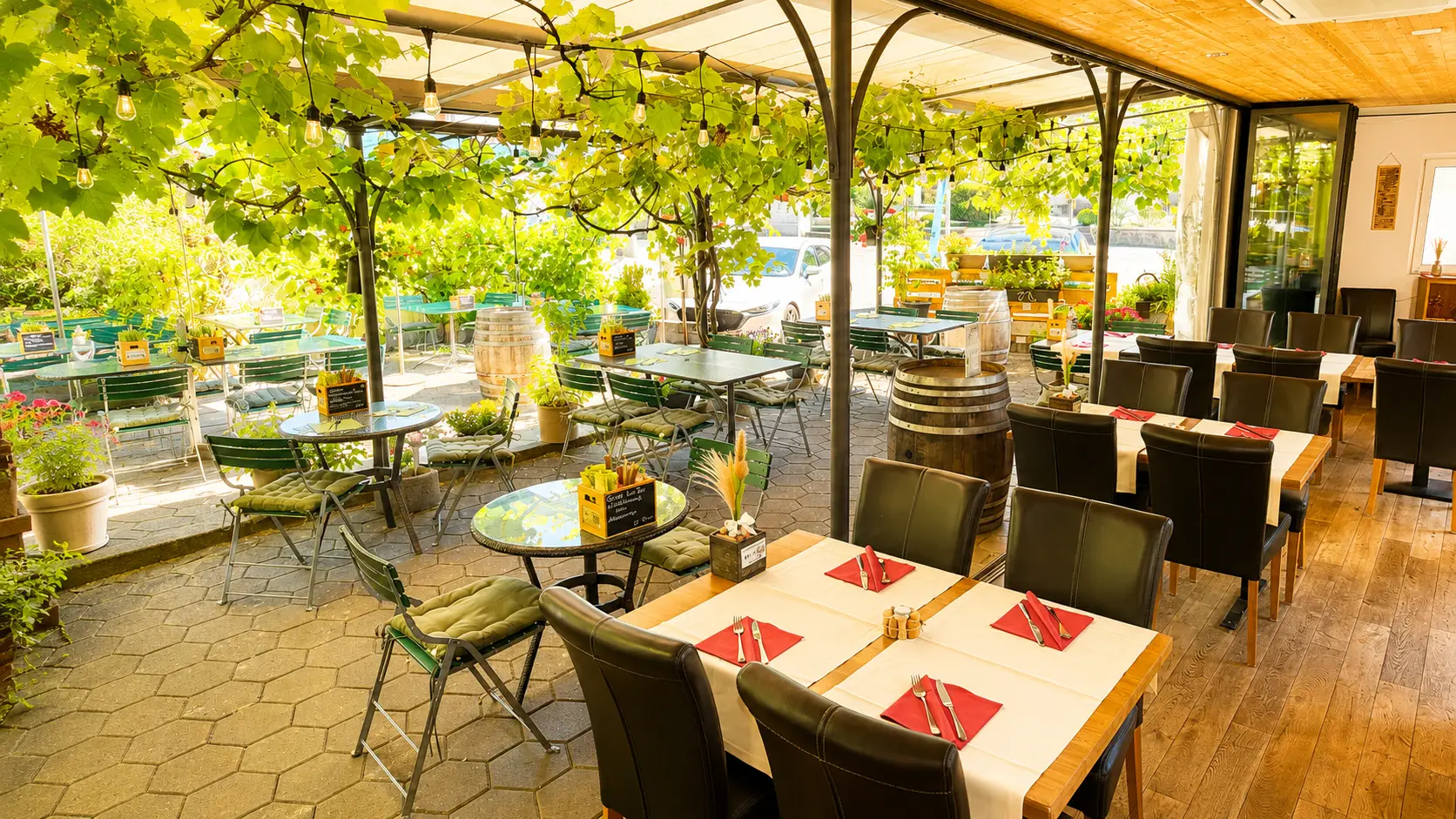 Übergang vom Wintergarten in den Gastgarten unter der Weinlaubpergola im Stadtgarten Wangen